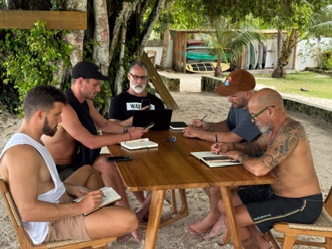 Builders journaling at a beach table