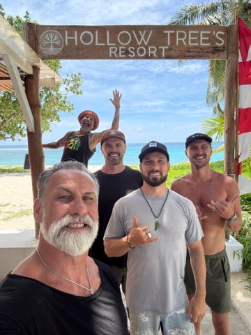 Faculty and hosts under Hollow Tree's Resort sign