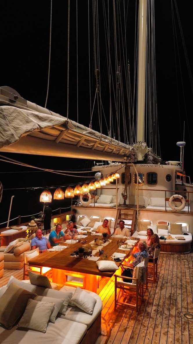 Wooden phinisi schooner with lantern dinner at night