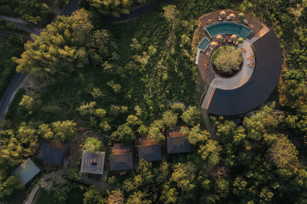 Aerial of round wellness venue carved into jungle