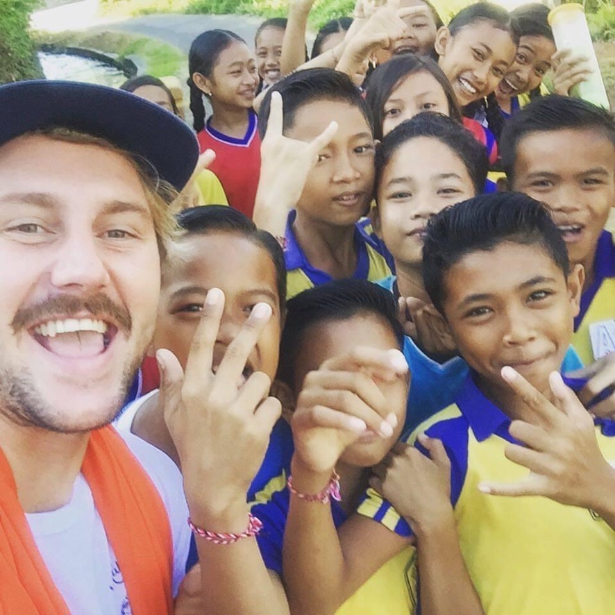Bridge founder with Balinese schoolchildren laughing